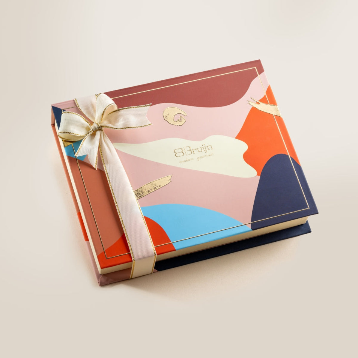 Closed Assorted Collection Box with modern abstract design in pink, blue, and warm tones, tied with a cream ribbon bow, ideal for gifting.