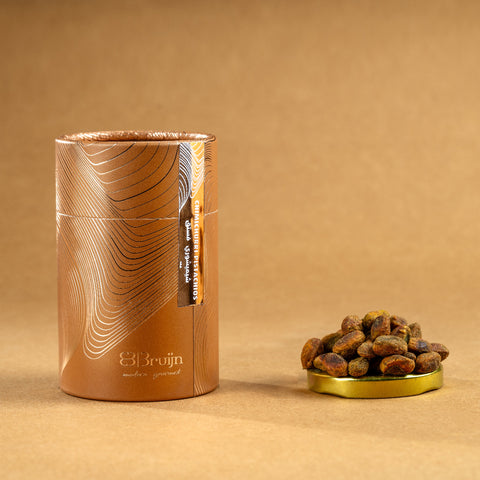 Brown cylindrical container of Bruijn Chimichurri Pistachios with minimalist design, containing pistachios coated in herb-rich chimichurri seasoning.