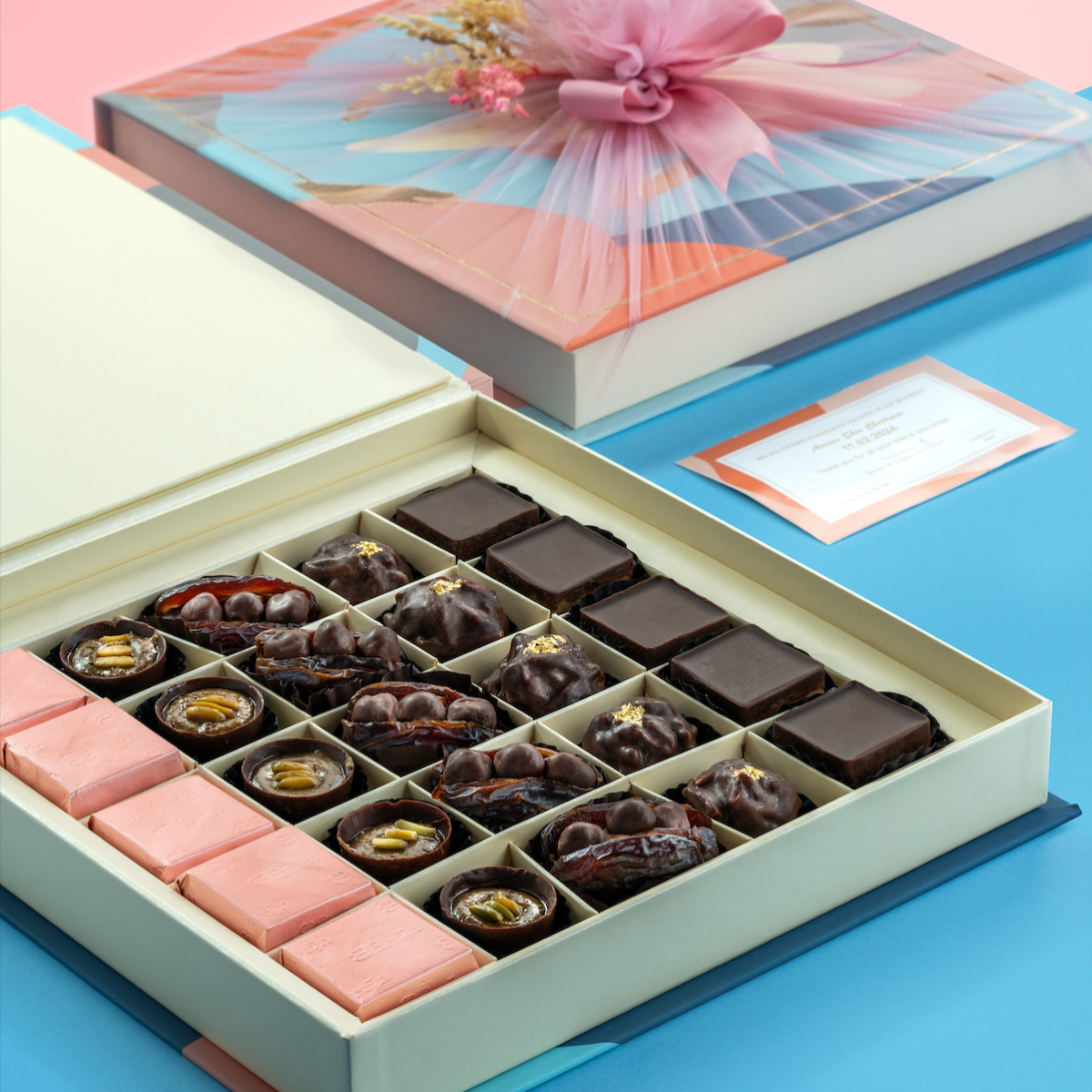 Opulent Chocolate Collection box with pink-wrapped cover featuring handmade chocolates, stuffed dates, pistachio cups, and fig tarts.