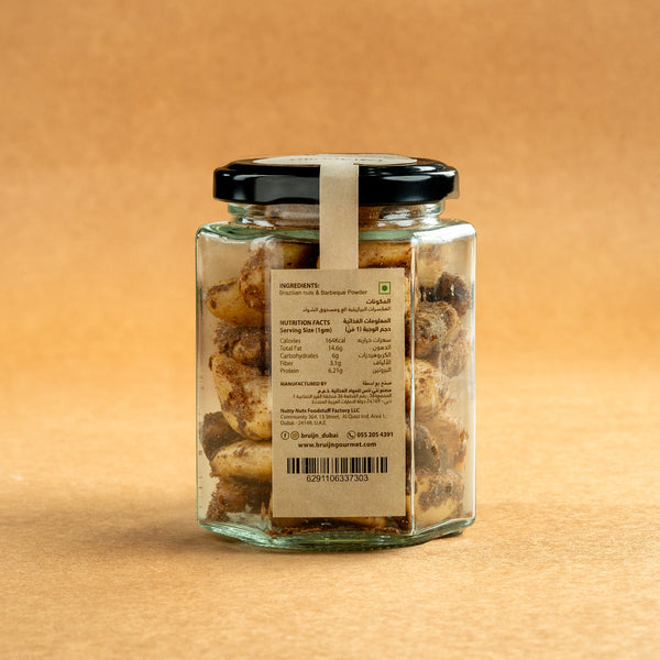 Glass jar of Bruijn Hickory Smoked Brazil Nuts with black lid and kraft label, filled with large Brazil nuts infused with smoky hickory flavour.