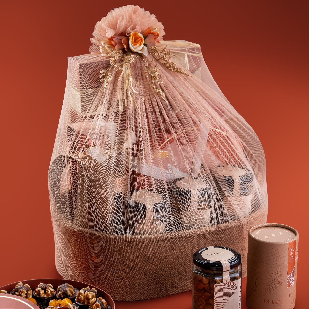 Elegant gift basket with fig & nut bites, date truffles, chocolate-dried fruit pairings, and flavored nut jars wrapped in festive packaging.