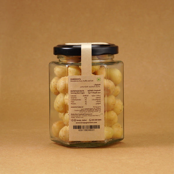 Glass jar of Bruijn Italian Black Truffle Macadamias with black lid and kraft label, filled with golden macadamia nuts coated in aromatic truffle seasoning.