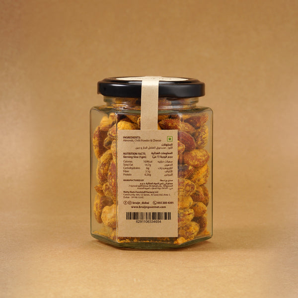 Glass jar of Bruijn Cheese & Chilli Almonds with a black lid and kraft label, showing golden almonds coated in cheese and chilli seasoning.