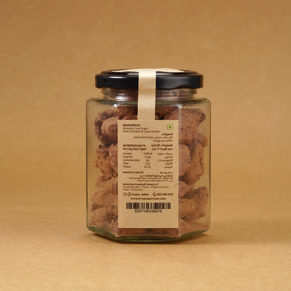 Glass jar of Bruijn Cocoa Dusted Almonds with black lid and kraft label, filled with chocolate-coated almonds dusted in rich cocoa powder.