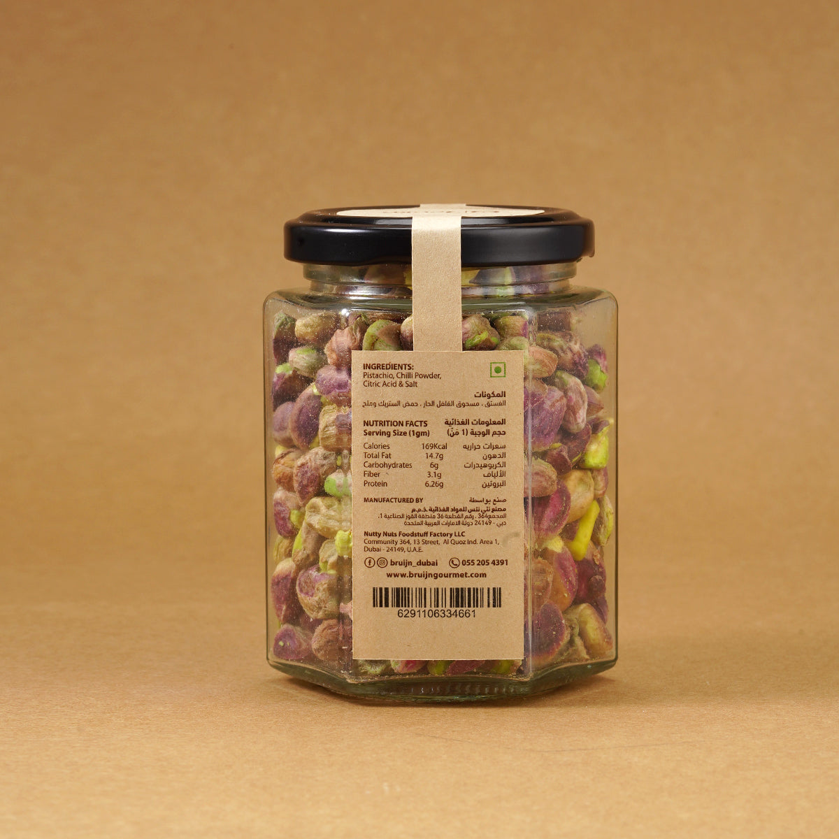 Glass jar of Bruijn Persian Lime & Chilli Pistachios with black lid and kraft label, filled with spiced pistachios coated in lime and chilli seasoning.