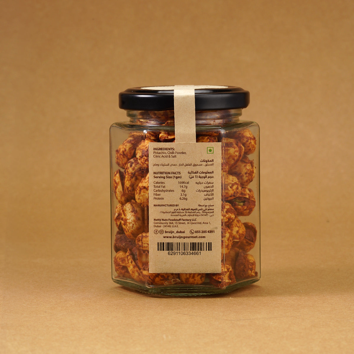 Glass jar of Bruijn Persian Lime & Chilli Pistachios with black lid and kraft label, filled with spiced pistachios coated in lime and chilli seasoning.