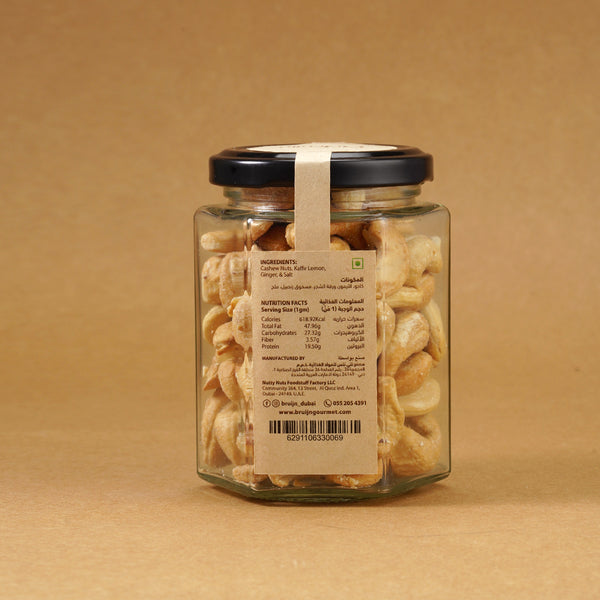 Glass jar of Bruijn Thai Herb Cashews with black lid and kraft label, filled with golden cashews coated in aromatic Thai herbs and spice seasoning.